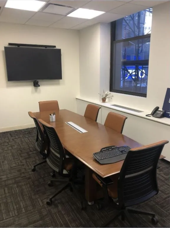 Conference Room with long table and wall mounted TV on far wall