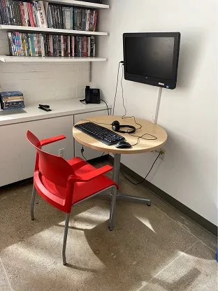 small round table with one red desk chair and keyboard